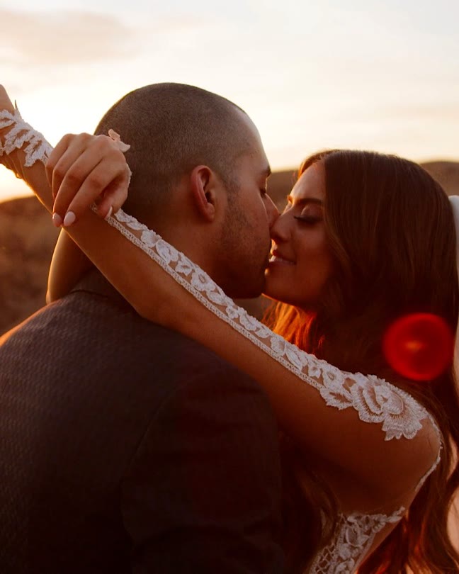 Edmond and Lauren kissing at sunset over the hills at Hummingbird Nest Ranch