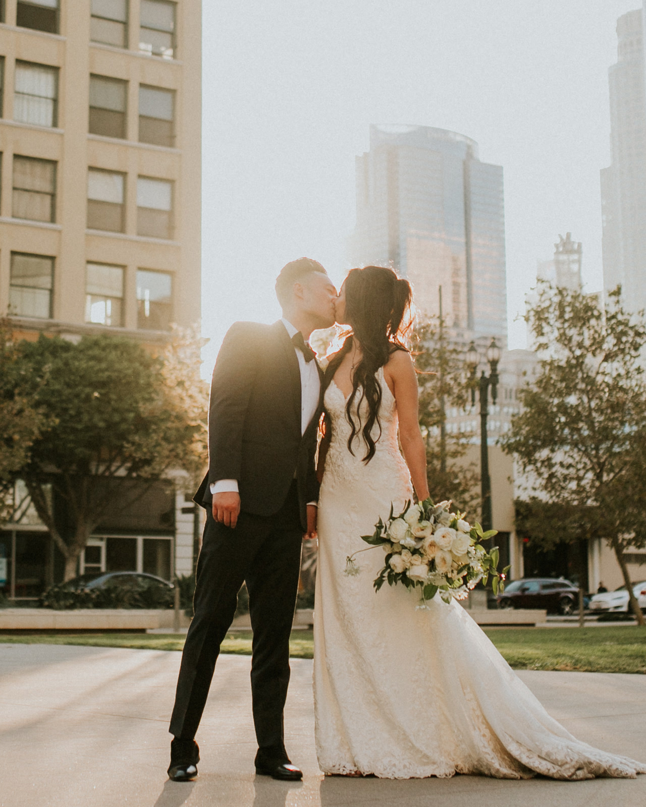 Matt and Leslie kissing at golden hour in downtown Los Angeles